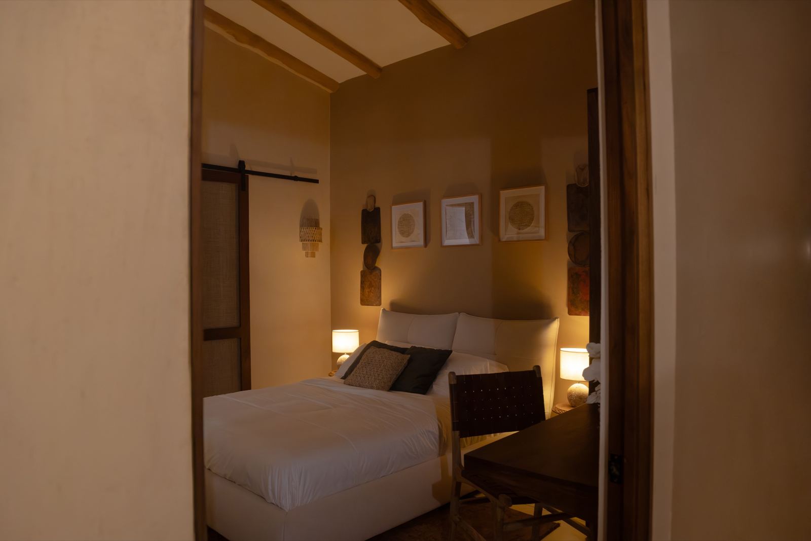 Segundo dormitorio visto desde la puerta: cama, cuadros y escritorio