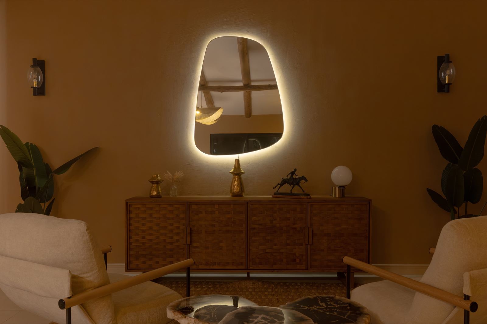 Espejo retroiluminado sobre el aparador de la sala, con piezas de latón y apliques encendidos