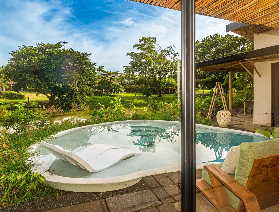 Piscina de Bergamota 13 con camastro, rodeada de jardín