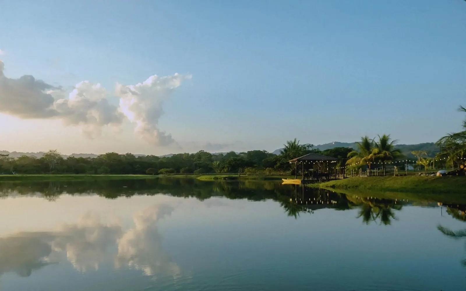 Laguna en calma rodeada de bosque tropical al amanecer, Costa Rica